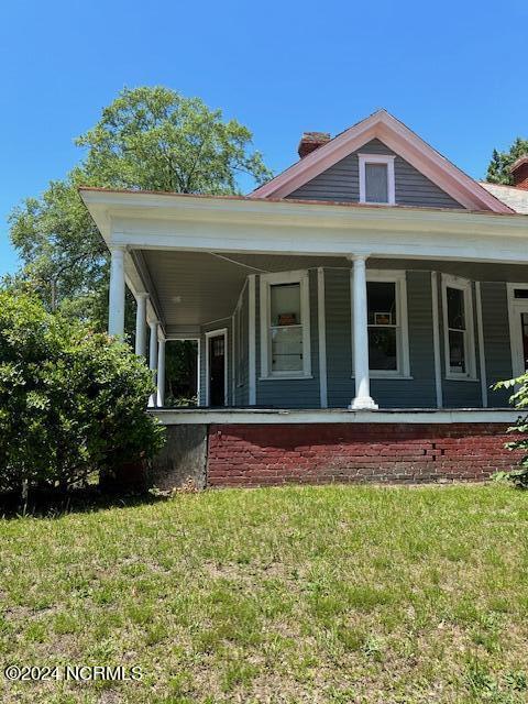 view of front of property featuring a front lawn and a porch