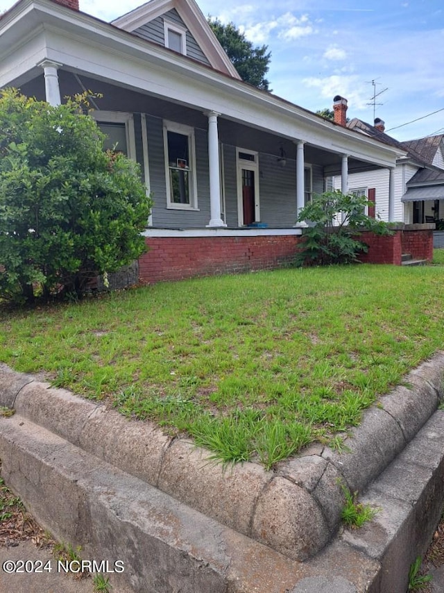 view of front of property with a front yard and covered porch