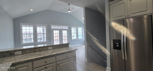 unfurnished living room featuring vaulted ceiling and light hardwood / wood-style flooring