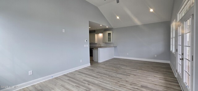 spare room featuring ceiling fan, light hardwood / wood-style flooring, french doors, and a healthy amount of sunlight