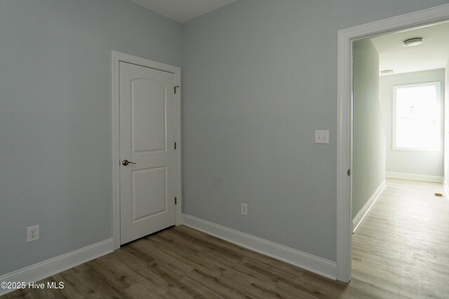 unfurnished bedroom with wood-type flooring, a closet, and ceiling fan