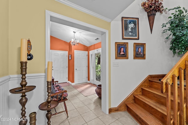 foyer entrance featuring an inviting chandelier, light tile patterned floors, and vaulted ceiling