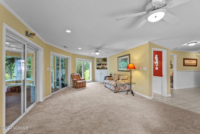 sitting room featuring tile patterned floors, built in features, carpet flooring, and ornamental molding