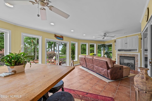 interior space with ceiling fan and a glass covered fireplace