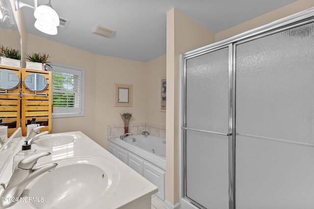 bathroom with dual vanity and independent shower and bath