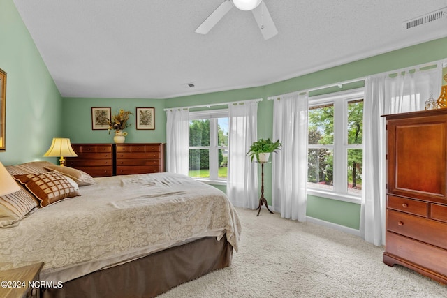 carpeted bedroom featuring ceiling fan and a textured ceiling