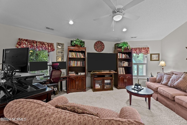 living area with carpet floors, a textured ceiling, visible vents, and a ceiling fan