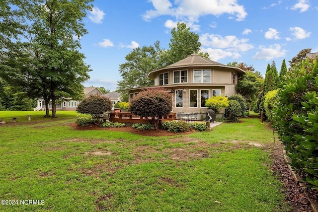 back of property with a deck and a yard