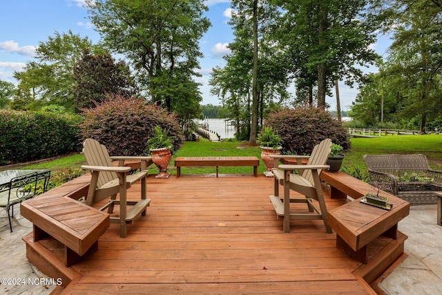 wooden terrace featuring a yard and a water view