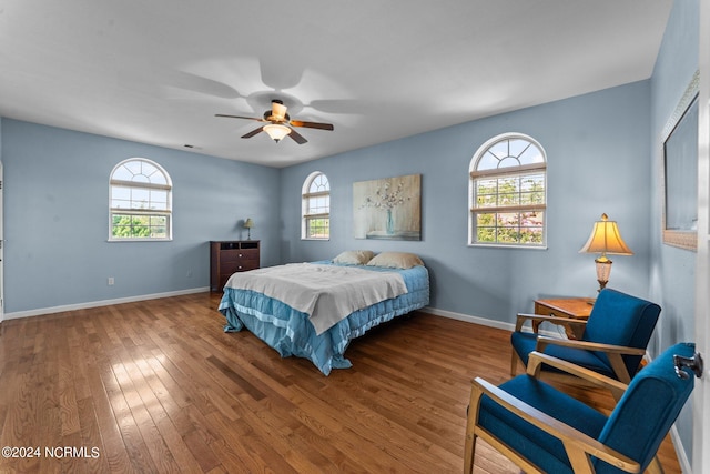 bedroom with multiple windows, ceiling fan, and hardwood / wood-style floors