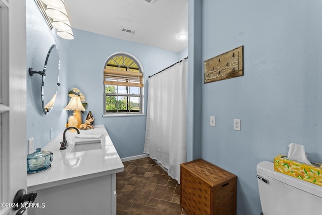 bathroom featuring vanity, tile patterned flooring, and toilet