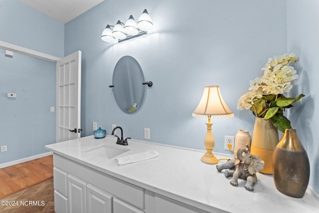 bathroom featuring wood finished floors, vanity, and baseboards