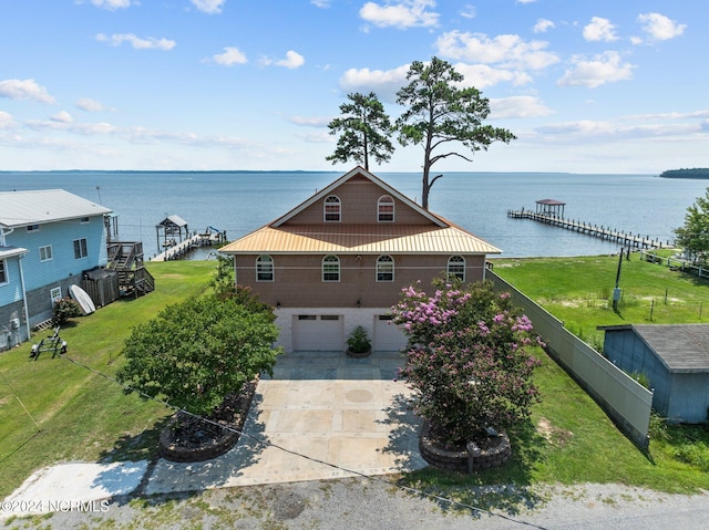 view of front of property featuring a water view, a garage, and a front yard