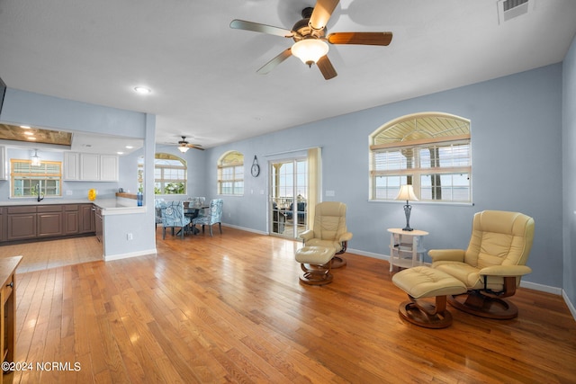 living area with ceiling fan and light hardwood / wood-style floors