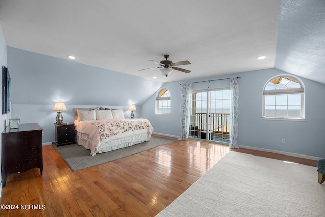 bedroom featuring hardwood / wood-style floors, multiple windows, and vaulted ceiling