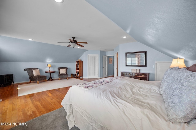 bedroom featuring lofted ceiling, a textured ceiling, ceiling fan, and wood-type flooring