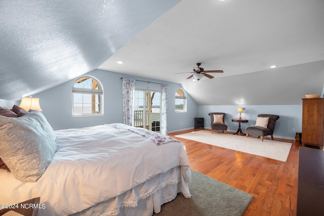 bedroom with hardwood / wood-style flooring, access to outside, a textured ceiling, lofted ceiling, and ceiling fan