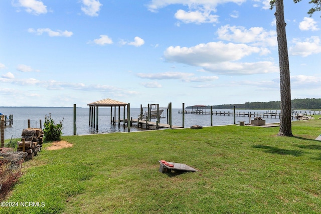 view of dock with a water view and a lawn