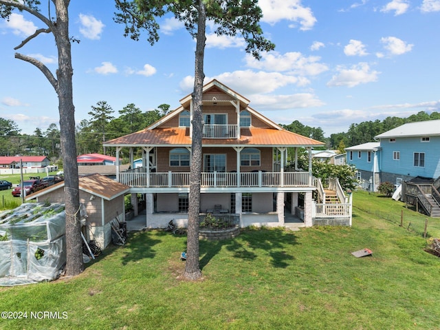 rear view of house with a balcony, a patio area, metal roof, and a yard