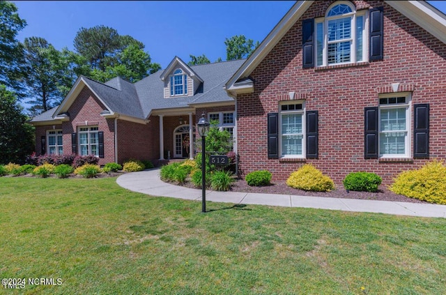 traditional-style house with a front lawn and brick siding