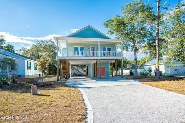 view of front facade with covered porch, a front lawn, and a carport