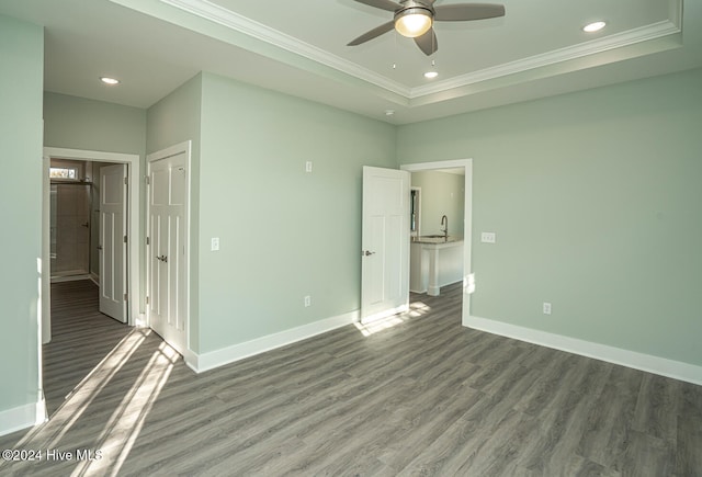 unfurnished bedroom featuring ceiling fan, dark hardwood / wood-style floors, ornamental molding, and a closet