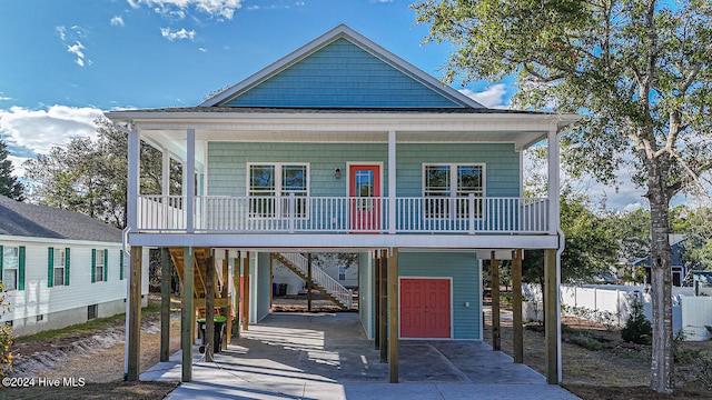 raised beach house with covered porch and a carport