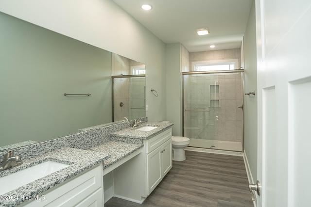 bathroom featuring toilet, vanity, wood-type flooring, and walk in shower