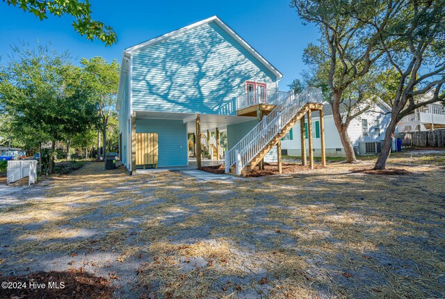 rear view of house with cooling unit and a wooden deck