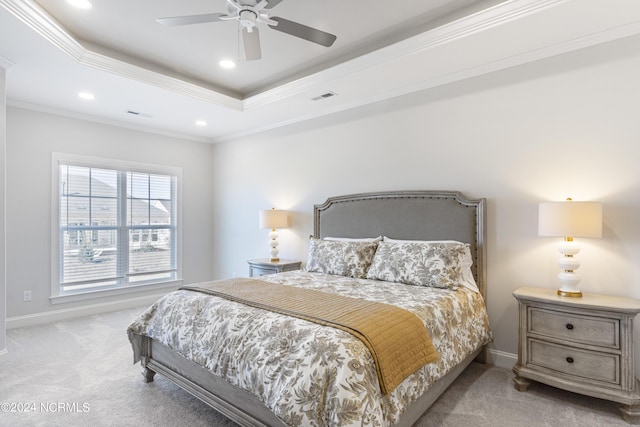 carpeted bedroom featuring a tray ceiling, visible vents, crown molding, and baseboards