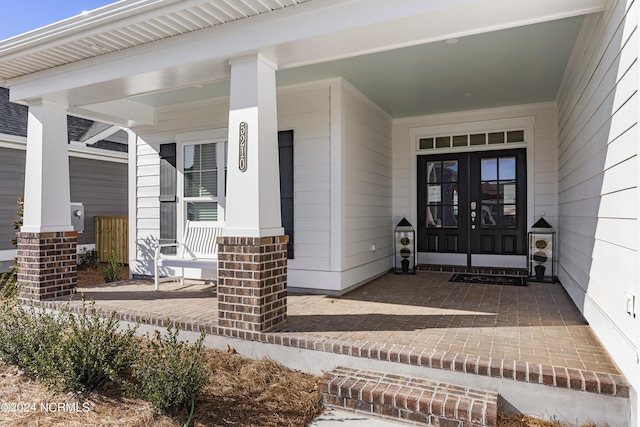 property entrance with a porch and french doors