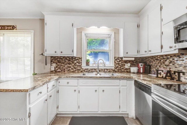 212 Bunche Dr, Goldsboro, NC 27530 - kitchen featuring appliances with stainless steel finishes, decorative backsplash, a peninsula, and white cabinetry