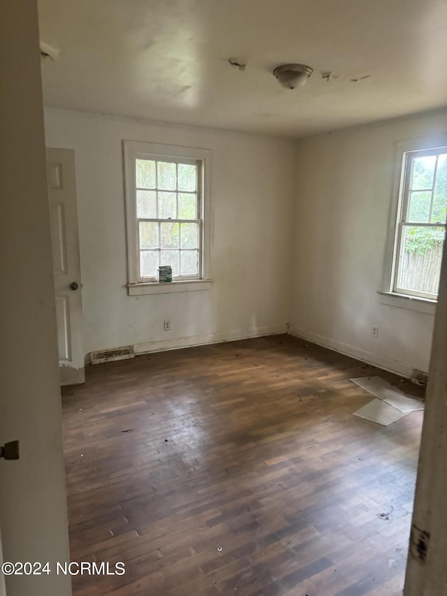 unfurnished room featuring dark hardwood / wood-style flooring and a wealth of natural light