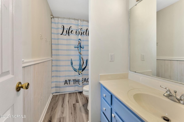 bathroom with hardwood / wood-style floors, vanity, toilet, and a shower with curtain