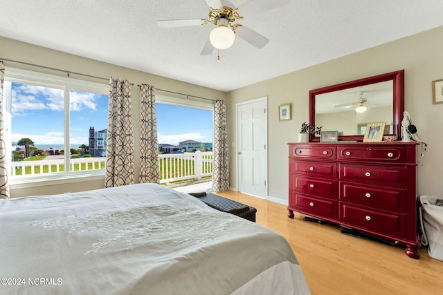 bedroom featuring a textured ceiling, light wood-type flooring, and ceiling fan