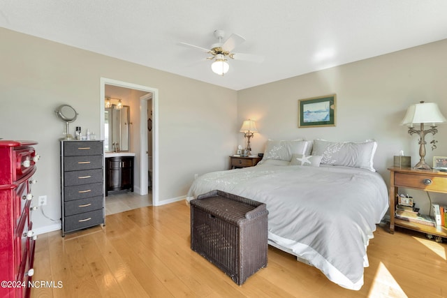 bedroom with hardwood / wood-style flooring, ceiling fan, and ensuite bath