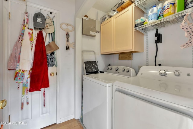 laundry area with washer and clothes dryer, cabinets, and light hardwood / wood-style floors