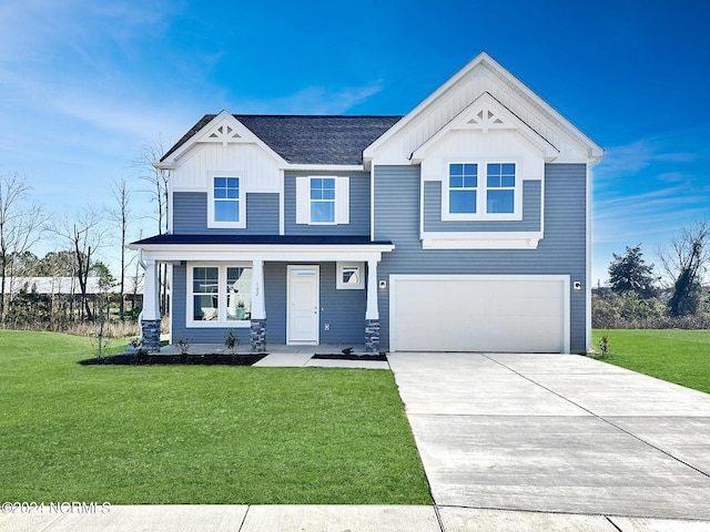 view of front of property featuring a garage, a front yard, and a porch