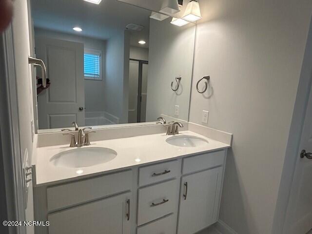 bathroom with vanity and a shower with shower door