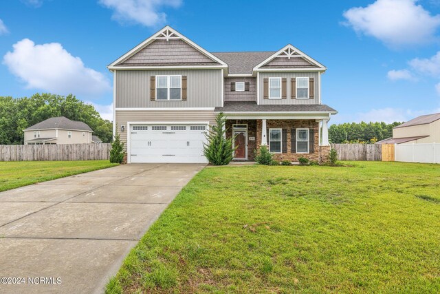 craftsman inspired home with a garage and a front yard