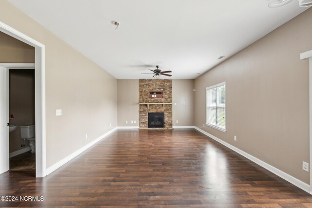 unfurnished living room with a stone fireplace, ceiling fan, and hardwood / wood-style flooring