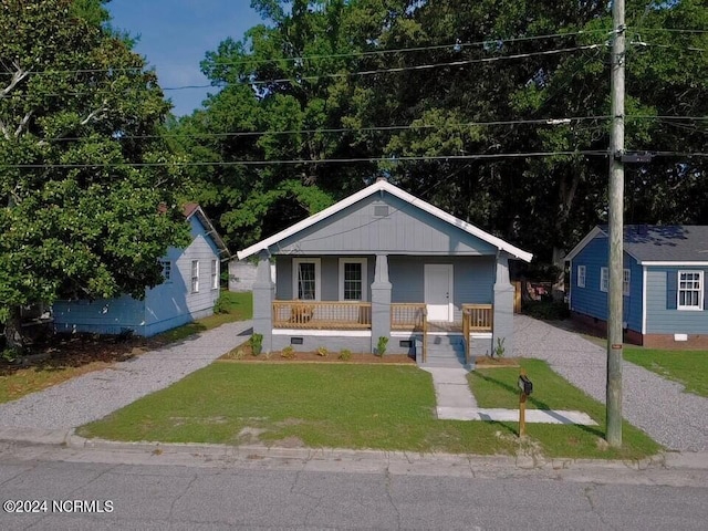 bungalow-style house with a front lawn and covered porch