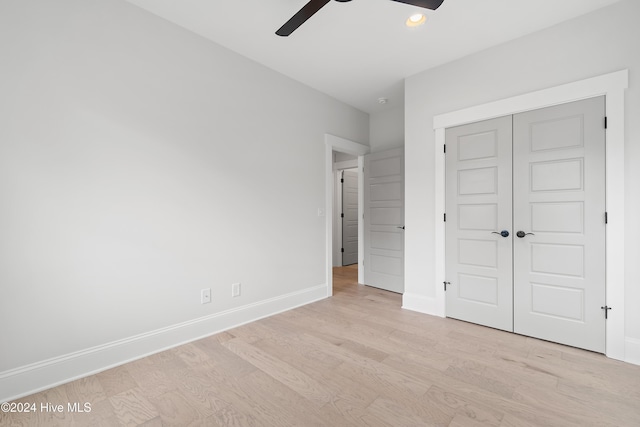 unfurnished bedroom featuring a closet, light hardwood / wood-style floors, and ceiling fan