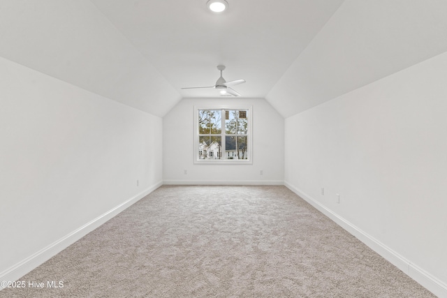 additional living space with lofted ceiling, carpet, a ceiling fan, and baseboards