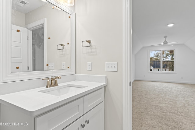 bathroom with ceiling fan, visible vents, vanity, vaulted ceiling, and baseboards