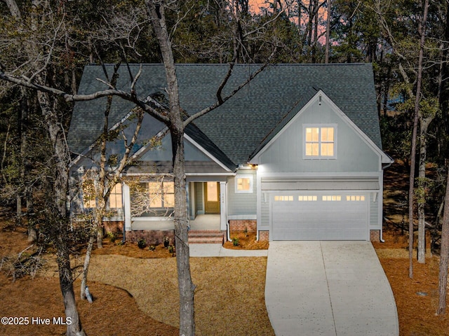 view of front of property with a shingled roof, concrete driveway, and a garage