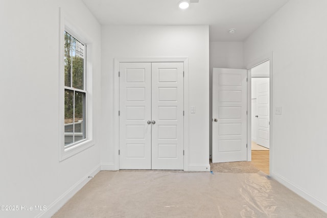 unfurnished bedroom with a closet and baseboards