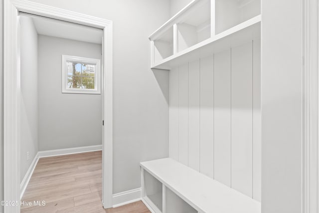 mudroom featuring light wood finished floors and baseboards