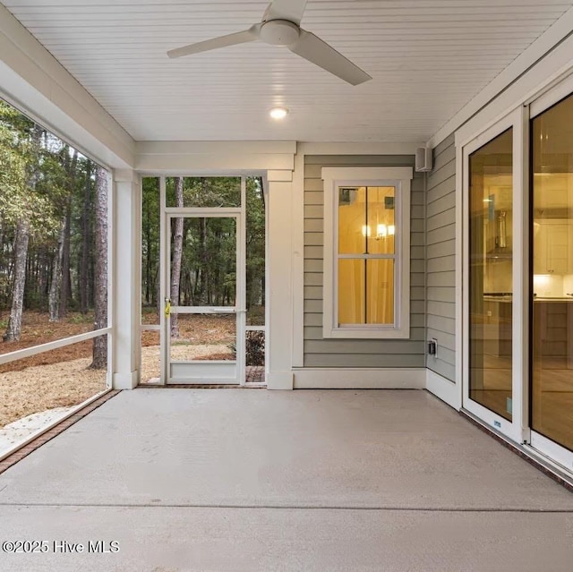 unfurnished sunroom with ceiling fan