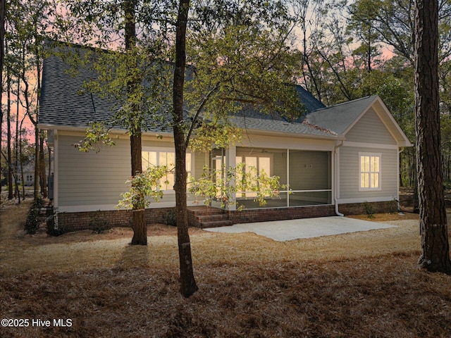 view of front of home featuring a shingled roof and a sunroom